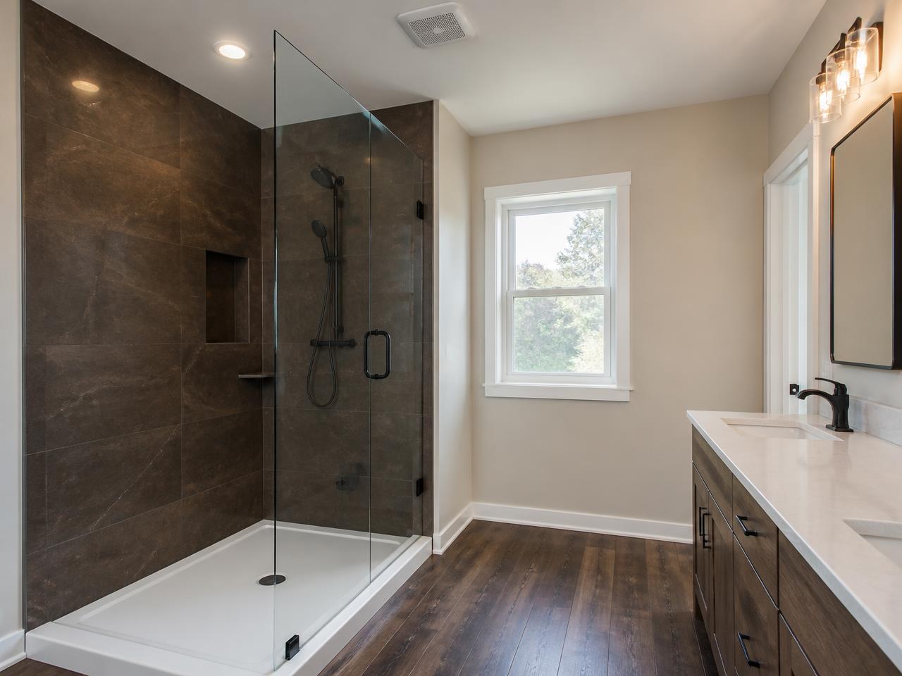 Warm espresso brown stone-look bathroom with seamless walk-in shower and frameless glass